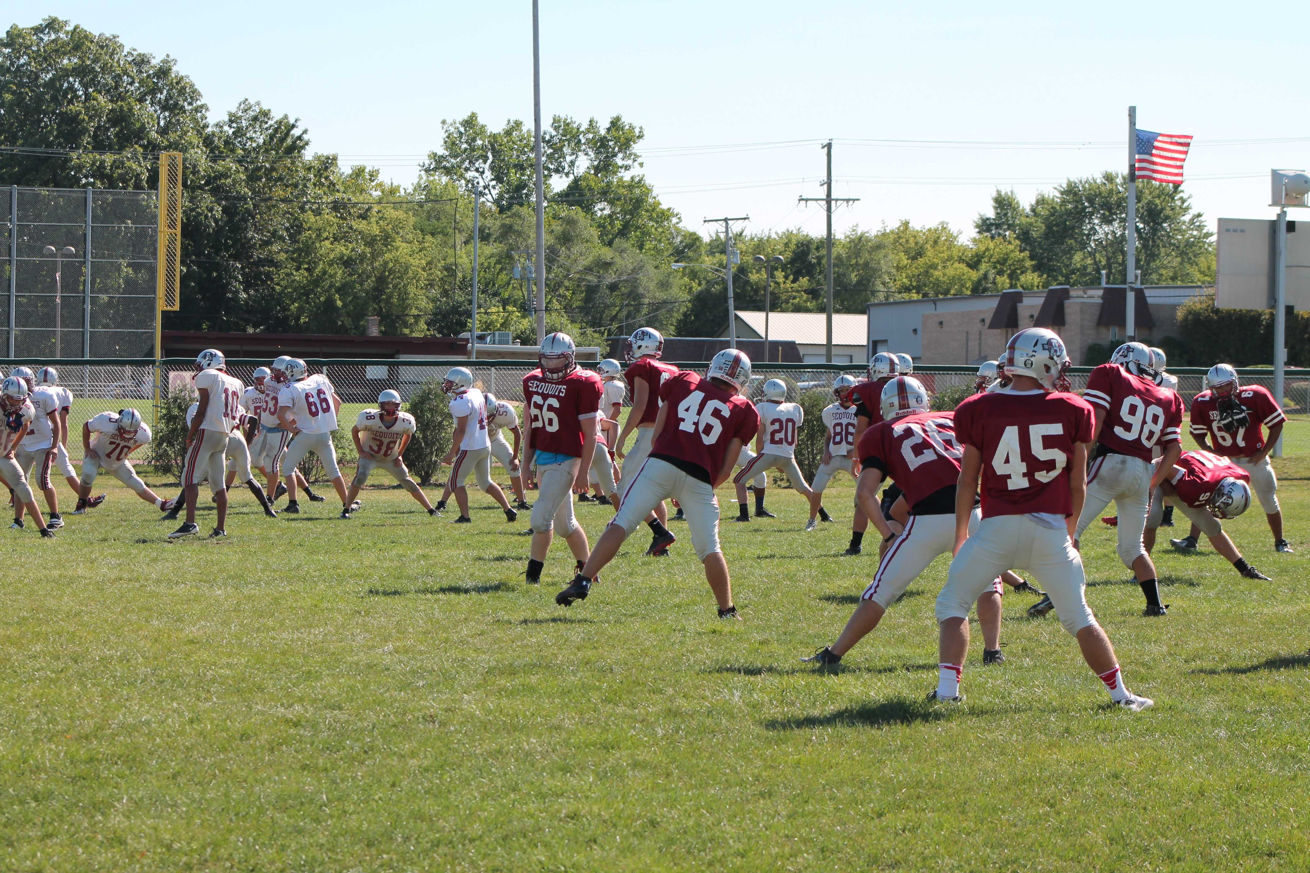 The varsity foot ball team is warming up for practice. 